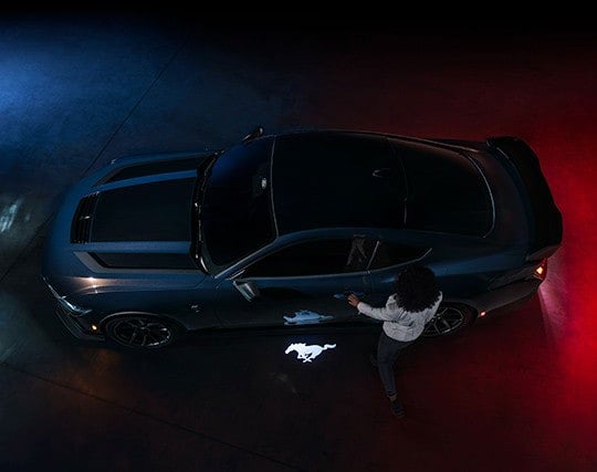 2024 Ford Mustang® Dark Horse™ model with a driver approaching the vehicle | Lynch Ford of Mukwonago in Mukwonago WI